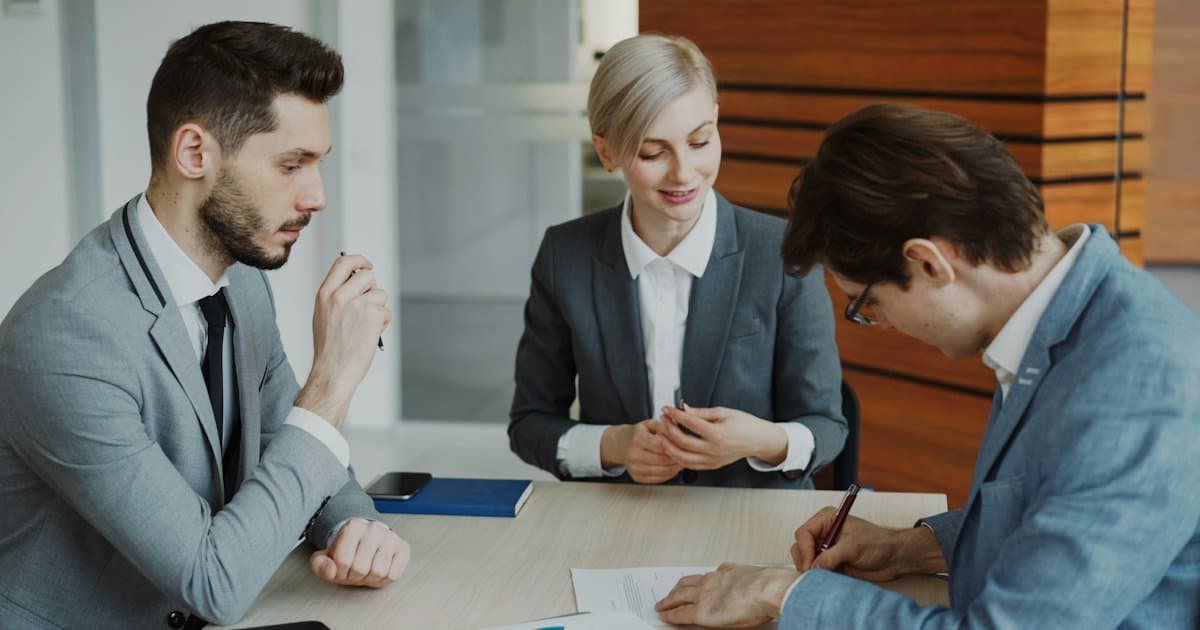 Consultor e cliente conversando sobre documentos de plano de saúde em um escritório