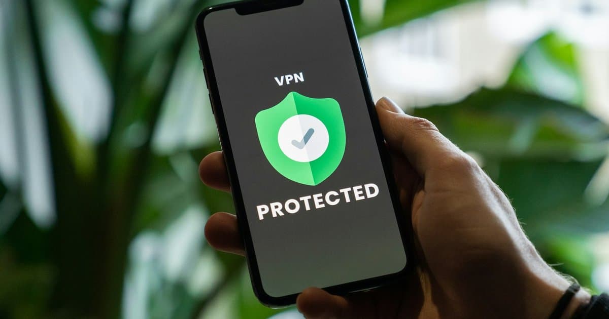 Pessoa segurando um smartphone com a tela protegida, representando a contratação de um seguro celular